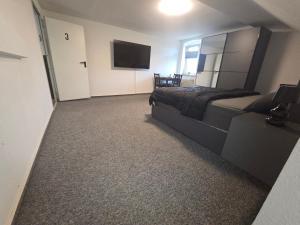 a bedroom with a bed and a flat screen tv at M-NOUr in Solingen