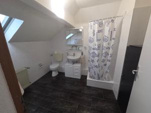a bathroom with a toilet and a shower curtain at M-NOUr in Solingen