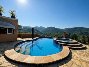 a swimming pool in a resort with mountains in the background at Pousada Santa Fe de Penedo in Penedo