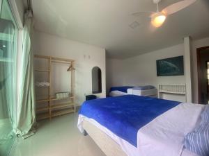 a bedroom with a bed with a blue blanket at Requinte e Conforto na Praia do Morro in Guarapari