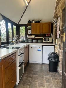 a kitchen with a sink and a stove top oven at The Old Mill and Cottage in Matlock