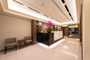 a lobby with chairs and a counter with purple flowers at Sir Motel - Sanchong in Taipei