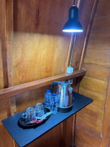 a table with a tea kettle and glasses on it at Pondok Kebun Sayur in Bedugul