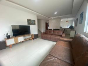 a living room with a couch and a flat screen tv at Requinte e Conforto na Praia do Morro in Guarapari
