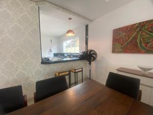 a dining room with a wooden table and chairs at Requinte e Conforto na Praia do Morro in Guarapari