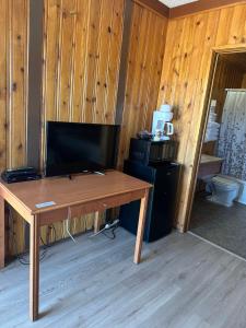 a room with a wooden table and a television at Glacier View Inn in Haines Junction