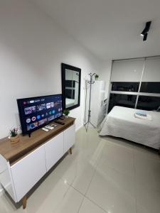a bedroom with a bed and a flat screen tv at Monoambiente como en casa in Montevideo