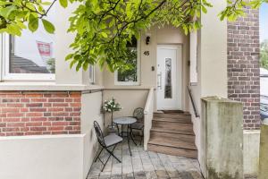 a home with a porch with a table and chairs at Ambiente Apartment in Olfen