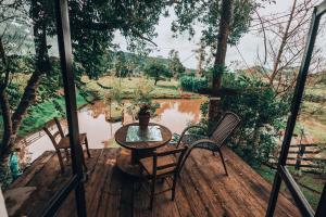 a patio with a table and chairs and a pond at Chalé dos Alves in Morro Azul +40 photos