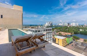 a balcony with two chairs and a pool on a building at Stylish Duplex Loft - Panoramic Rooftop Pool in Cartagena de Indias