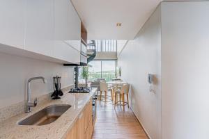 a kitchen with a sink and a table with chairs at Stylish Duplex Loft - Panoramic Rooftop Pool in Cartagena de Indias
