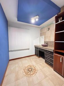 a large kitchen with a blue ceiling and a tile floor at Barrio Parque Residence in Caleta Olivia +3 photos