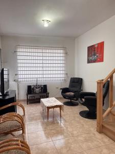 a living room with couches and chairs and a table at Barrio Parque Residence in Caleta Olivia
