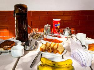 a table topped with plates of food and a banana at Casa Smile in Teresópolis