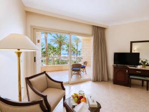 a living room with a room with a desk and a television at Sea Star Beau Rivage Hotel in Hurghada