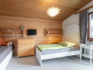 a bedroom with a bed and a tv in a room at Familien Lodge Fleckalm in Kirchberg in Tirol
