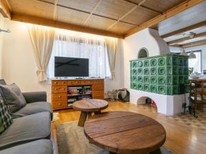 a living room with a couch and a table and a tv at Familien Lodge Fleckalm in Kirchberg in Tirol