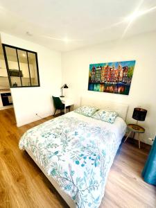 a bedroom with a bed and a painting on the wall at Gare sud in Rennes