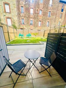 a patio with two chairs and a table and a building at Gare sud in Rennes