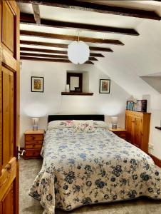 a bedroom with a bed with a blue and white comforter at The Old Mill and Cottage in Matlock