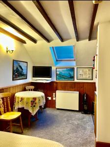 a room with a table and a tv on the wall at The Old Mill and Cottage in Matlock