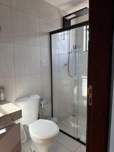 a bathroom with a toilet and a glass shower at RESIDENCIAL MORADA DO VALE 03b in Garanhuns +11 photos