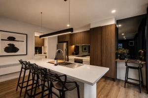 a kitchen with a white counter top and chairs at Black Sheep alpine getaways in Dinner Plain +2 photos