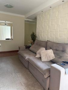 a living room with a gray couch and a mirror at Apartamento Serra Espírito Santo in Serra