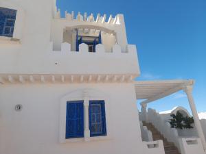 a white building with blue windows and stairs at Taguermess Tag 8 in Taguermess +13 photos