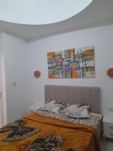 a bedroom with a bed with a painting on the wall at Taguermess Tag 8 in Taguermess