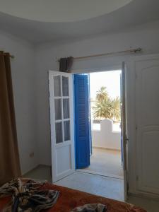 an open door to a room with a palm tree at Taguermess Tag 8 in Taguermess