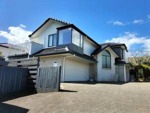 a white house with a fence in front of it at Mount Handy Dandy in Mount Maunganui