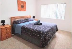 a bedroom with two beds and a dresser and a window at Mount Handy Dandy in Mount Maunganui