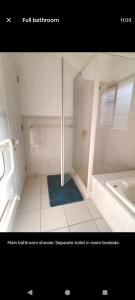 a white bathroom with a shower and a sink at Mount Handy Dandy in Mount Maunganui +7 photos