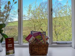 a basket of books in front of a window at Dewsnap Spring- Rtt4 in Chinley