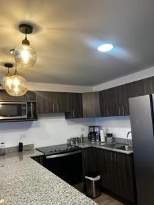 a kitchen with wooden cabinets and a counter top at Escápate-Room gt A 15 minutos del aereopuerto transporte gratis vista a los volcanes in Guatemala