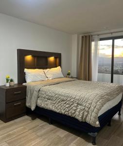 a bedroom with a large bed and a window at Escápate-Room gt A 15 minutos del aereopuerto transporte gratis vista a los volcanes in Guatemala