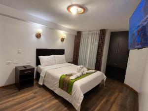 a bedroom with a bed with a stuffed animal on it at La Estancia de la Abuela Cusco Hotel in Cusco +17 photos