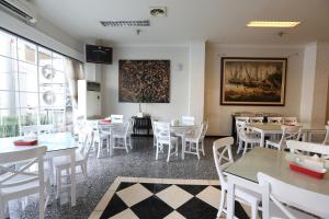 a dining room with white tables and white chairs at F Hotel Jakarta in Jakarta