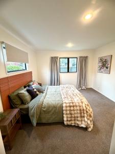 ein Schlafzimmer mit einem großen Bett in einem Zimmer in der Unterkunft Snow Fed House in Methven