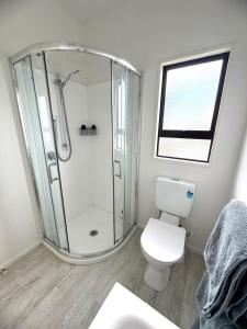 ein weißes Badezimmer mit Dusche und Toilette in der Unterkunft Snow Fed House in Methven + 24 Fotos