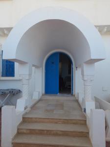 an archway with a blue door in a building at Taguermess Tag 6 in Midoun
