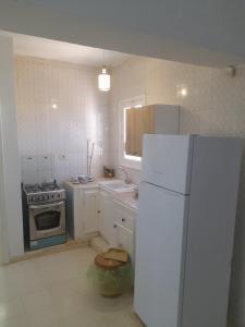 a kitchen with a white refrigerator and a stove at Taguermess Tag 6 in Midoun