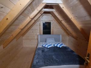 a bed in the attic of a tiny house at Nana Time Guesthouse in Vusanje