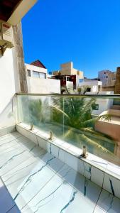 a balcony with a view of a palm tree on a building at Le Cocooning Mermoz-Batrain in Dakar