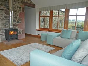a living room with a couch and a fireplace at Clochridgestone Cottage in Aberargie