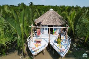 a small boat in the water with a hut at Iraboti Eco Resort Sundarban in Dhāngmāri Forest Office