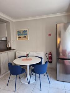 a kitchen with a table and chairs and a refrigerator at Appartement Esmeralda in Knokke-Heist