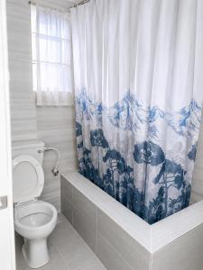 a bathroom with a toilet and a blue and white shower curtain at Tee's Place in Coker