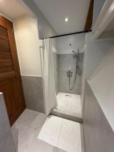 a bathroom with a shower with a shower curtain at Casitas de Boracay in Boracay +21 photos